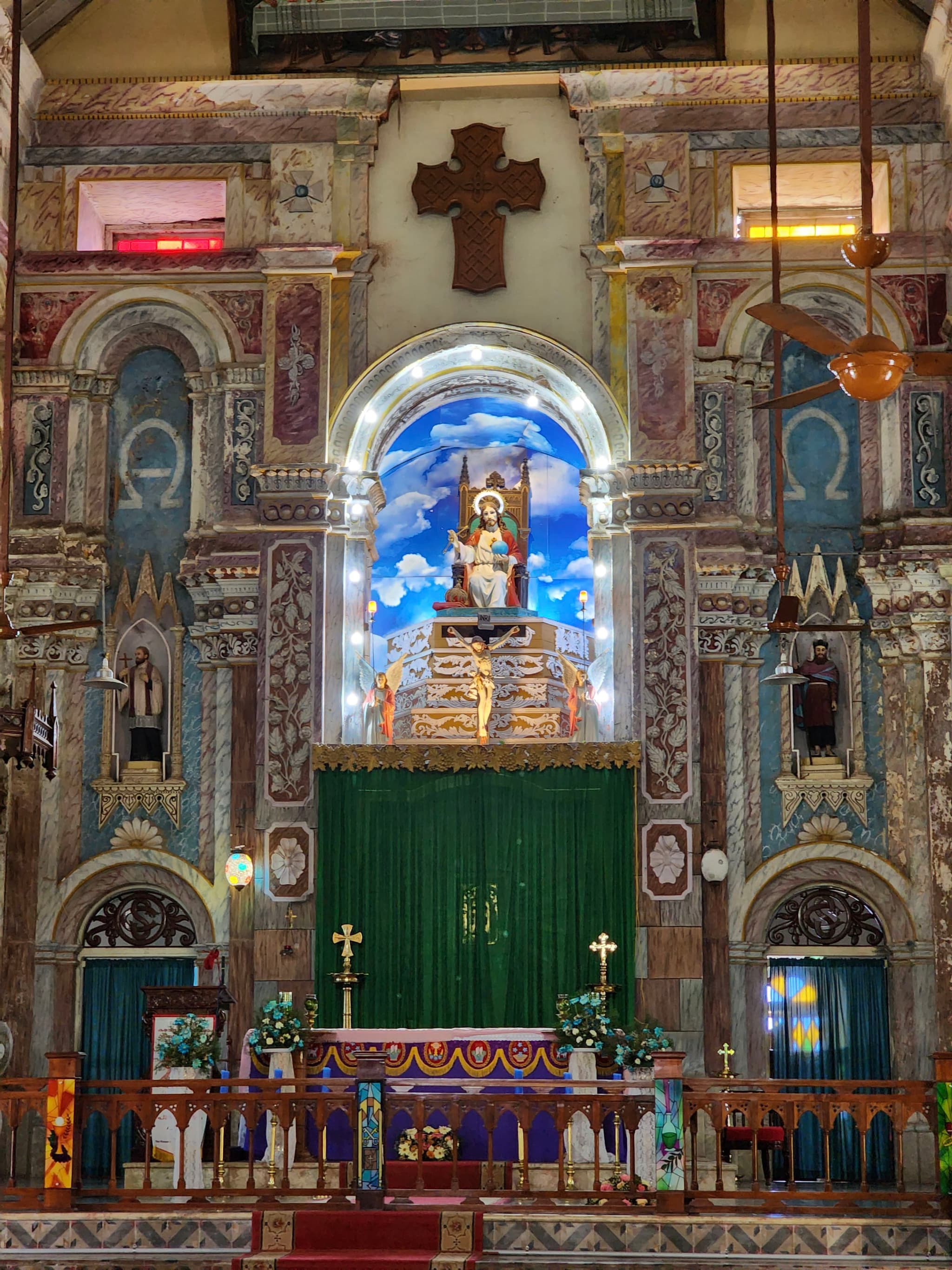 An ornate church altar with religious statues, a large crucifix, and intricate architectural details